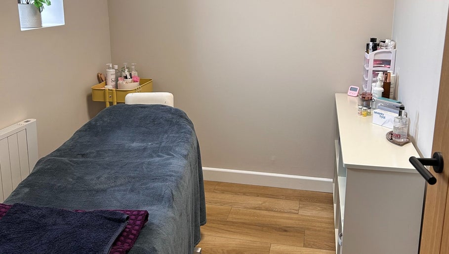 Treatment room at Defined Aesthetics & Beauty in Gamlingay, England. Cozy setting with massage bed.