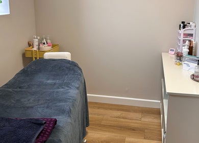 Treatment room at Defined Aesthetics & Beauty in Gamlingay, England. Cozy setting with massage bed.