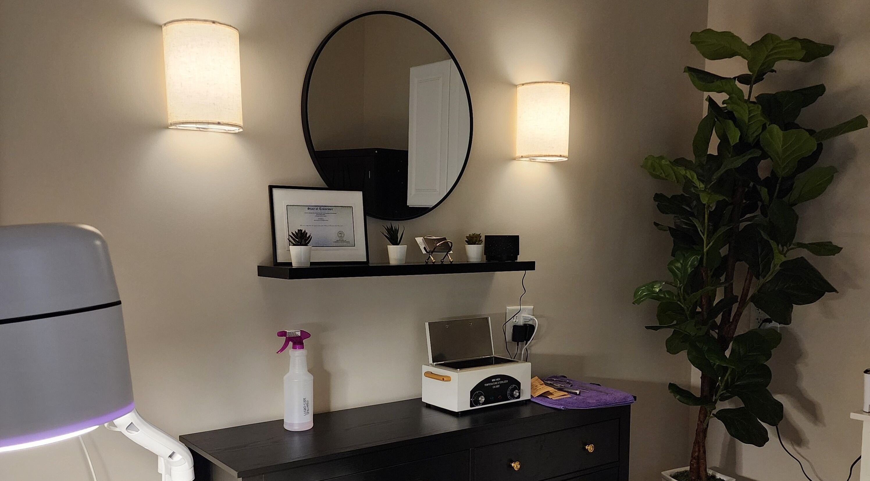 Elegant interior decor at Golden Kate Nails, Clarksville, Tennessee, featuring a mirror, plants, and soft lighting.