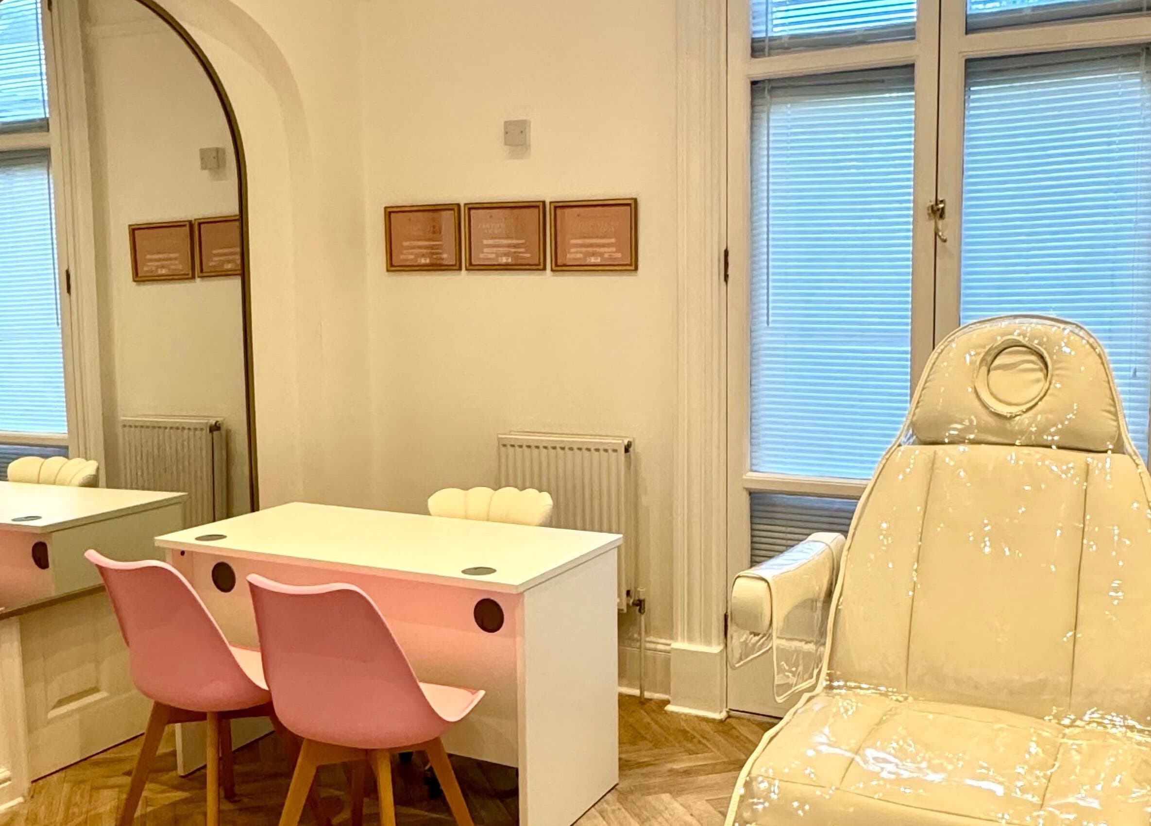 Elegant treatment room at Balanced Sculpt, Birmingham, England, GB featuring pink chairs and a plush recliner.