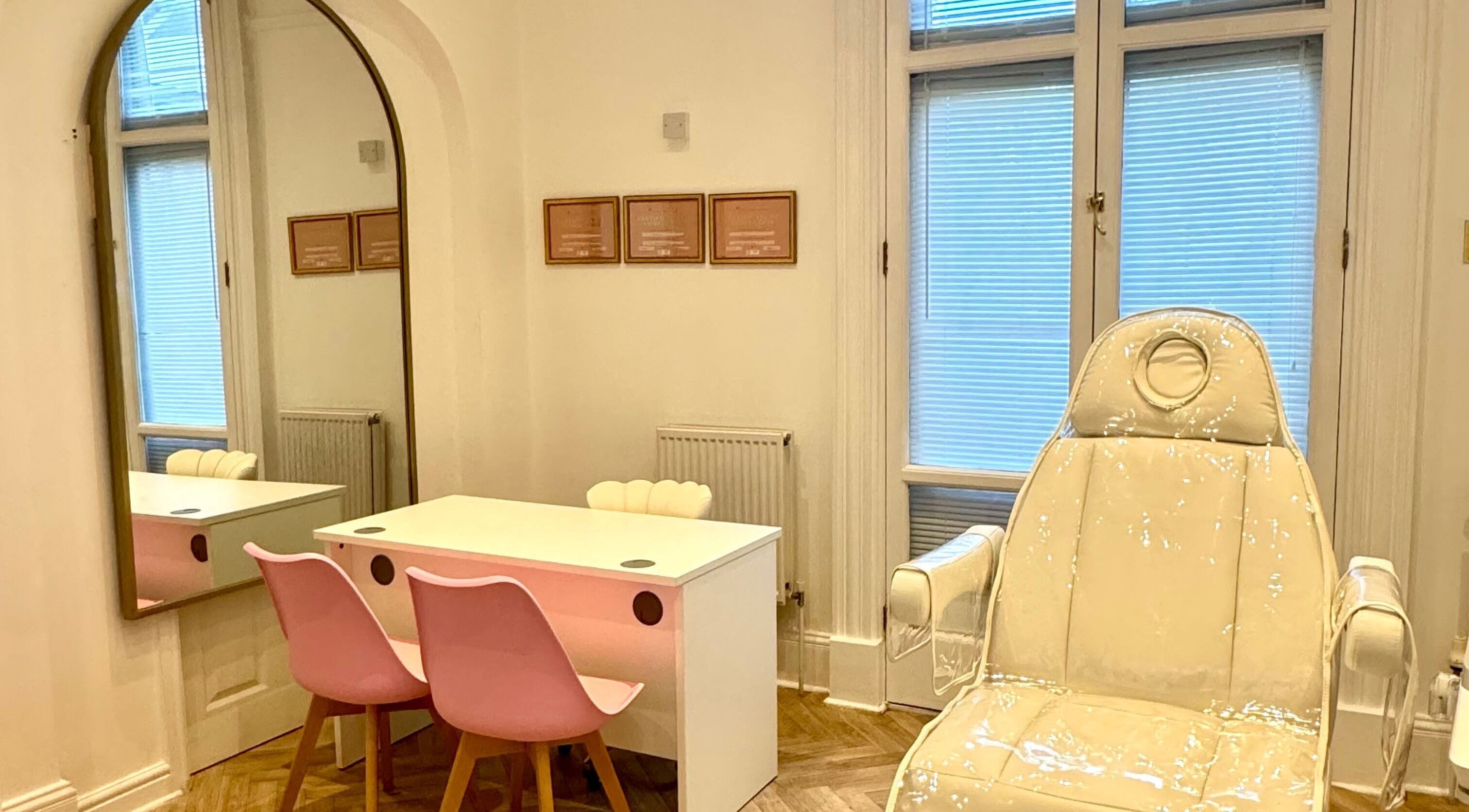 Elegant treatment room at Balanced Sculpt, Birmingham, England, GB featuring pink chairs and a plush recliner.