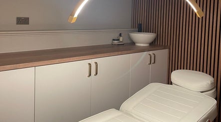 Serene treatment room at Aura Beauty in Aberdeen, Scotland, GB with a plush chair and elegant lighting.