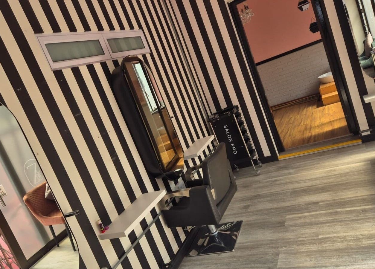 Modern salon interior at CheZel & Co, Springs, Gauteng, ZA with striped walls and stylish decor.
