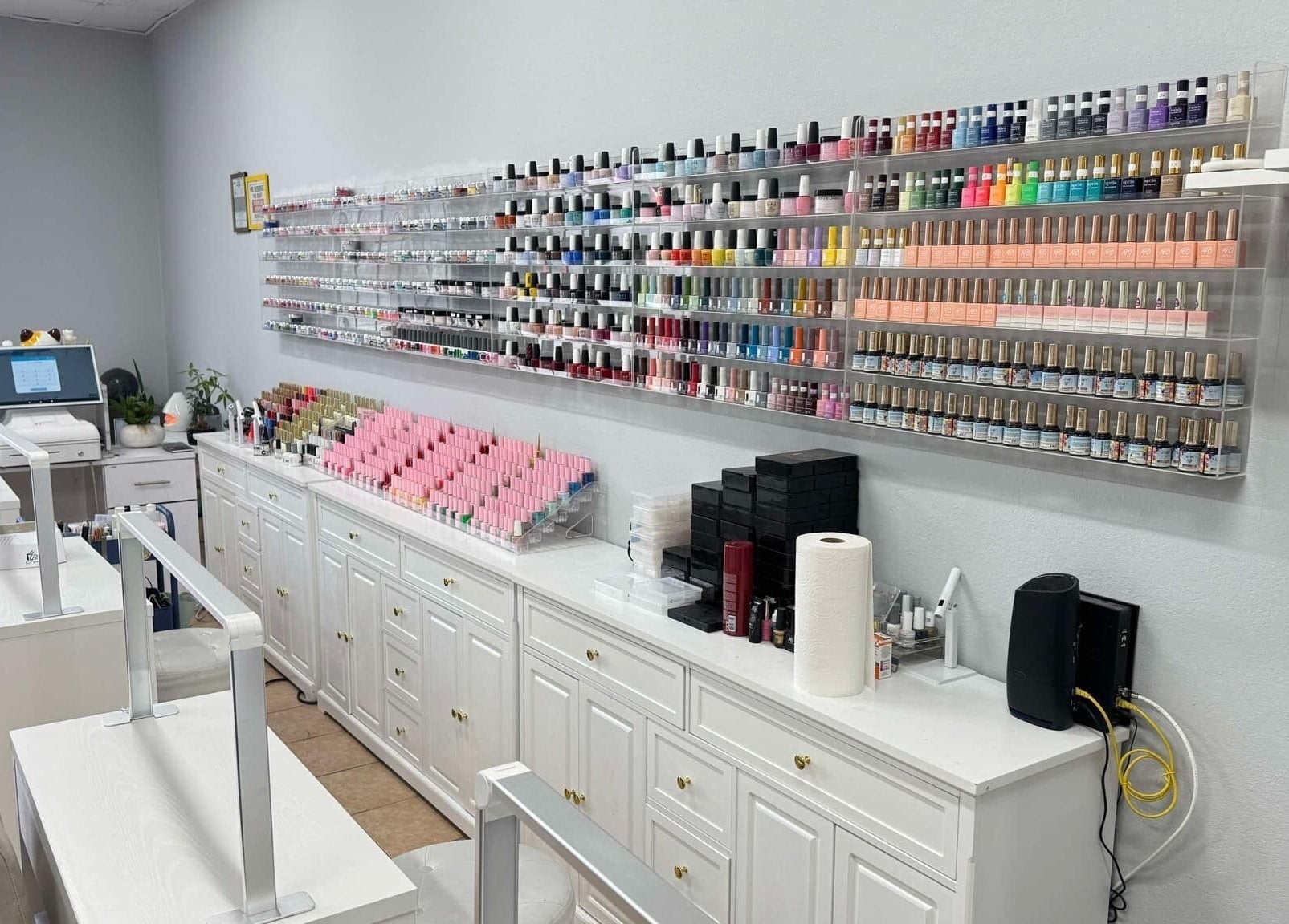 Nail polish display at Shiny Nails, Pasadena, California, US, showcasing vibrant shades in a modern salon.