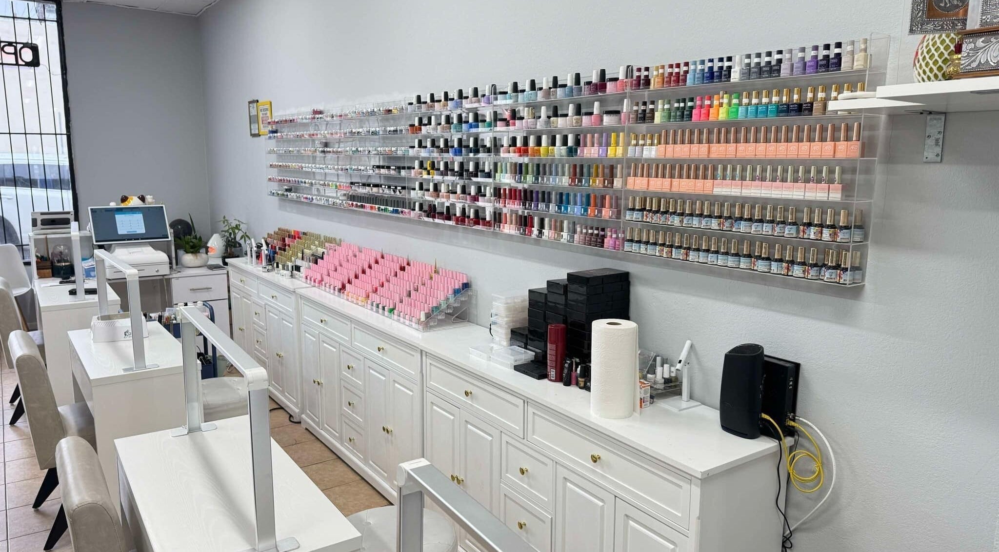 Nail polish display at Shiny Nails, Pasadena, California, US, showcasing vibrant shades in a modern salon.