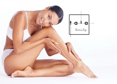 Smiling woman showcasing smooth skin at Tala Beauty Bar in Toronto, Ontario, CA.