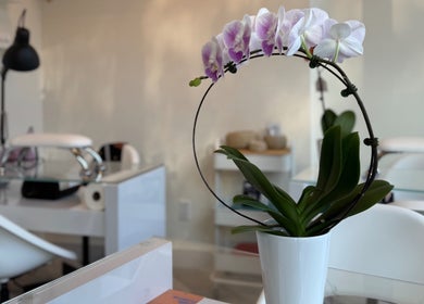 A serene manicure station with orchids at Tala Beauty Bar, Toronto, Ontario, CA, showcasing a peaceful ambiance.