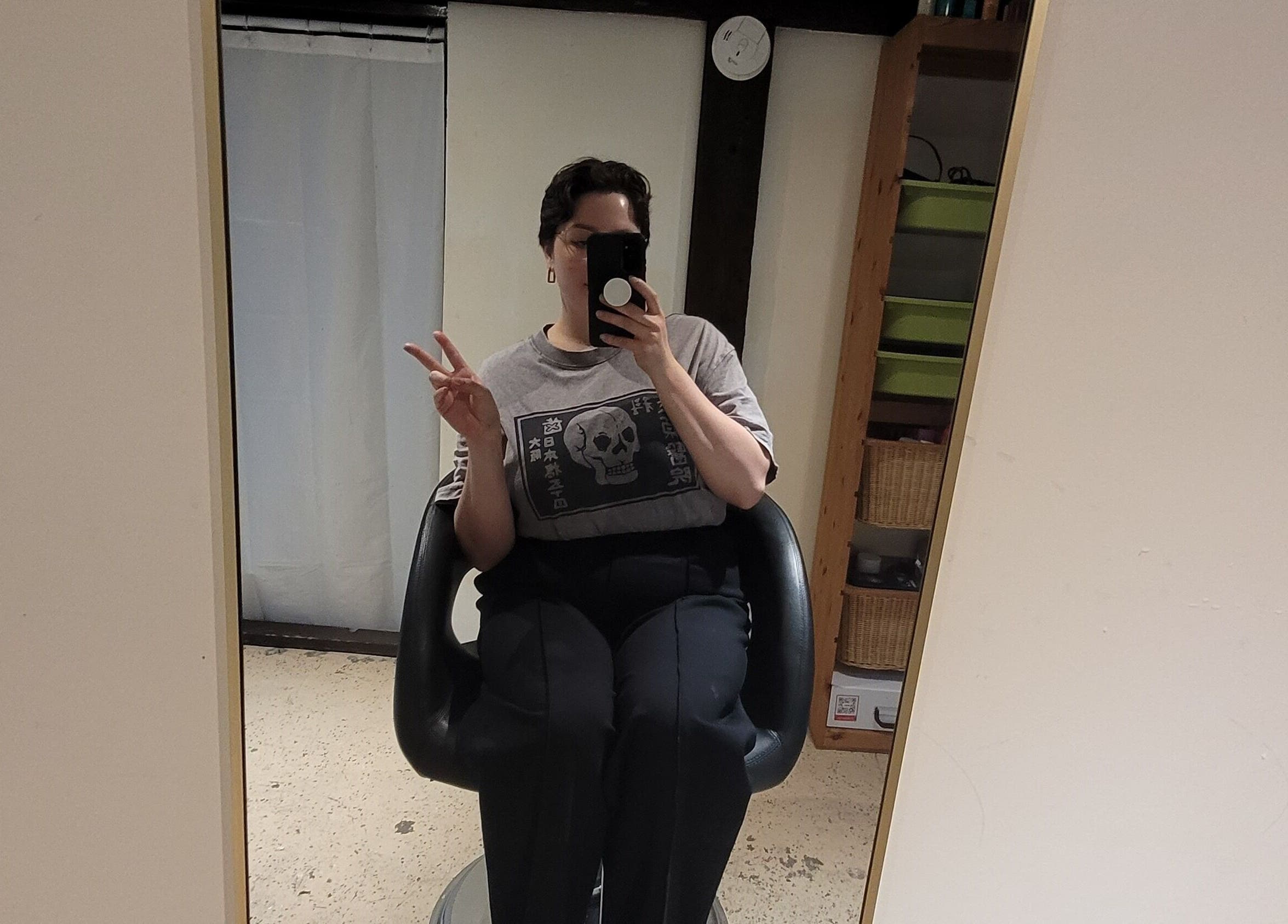 Relaxed individual in salon chair at Styled By Tylore, Vancouver, British Columbia, CA displaying peace sign.