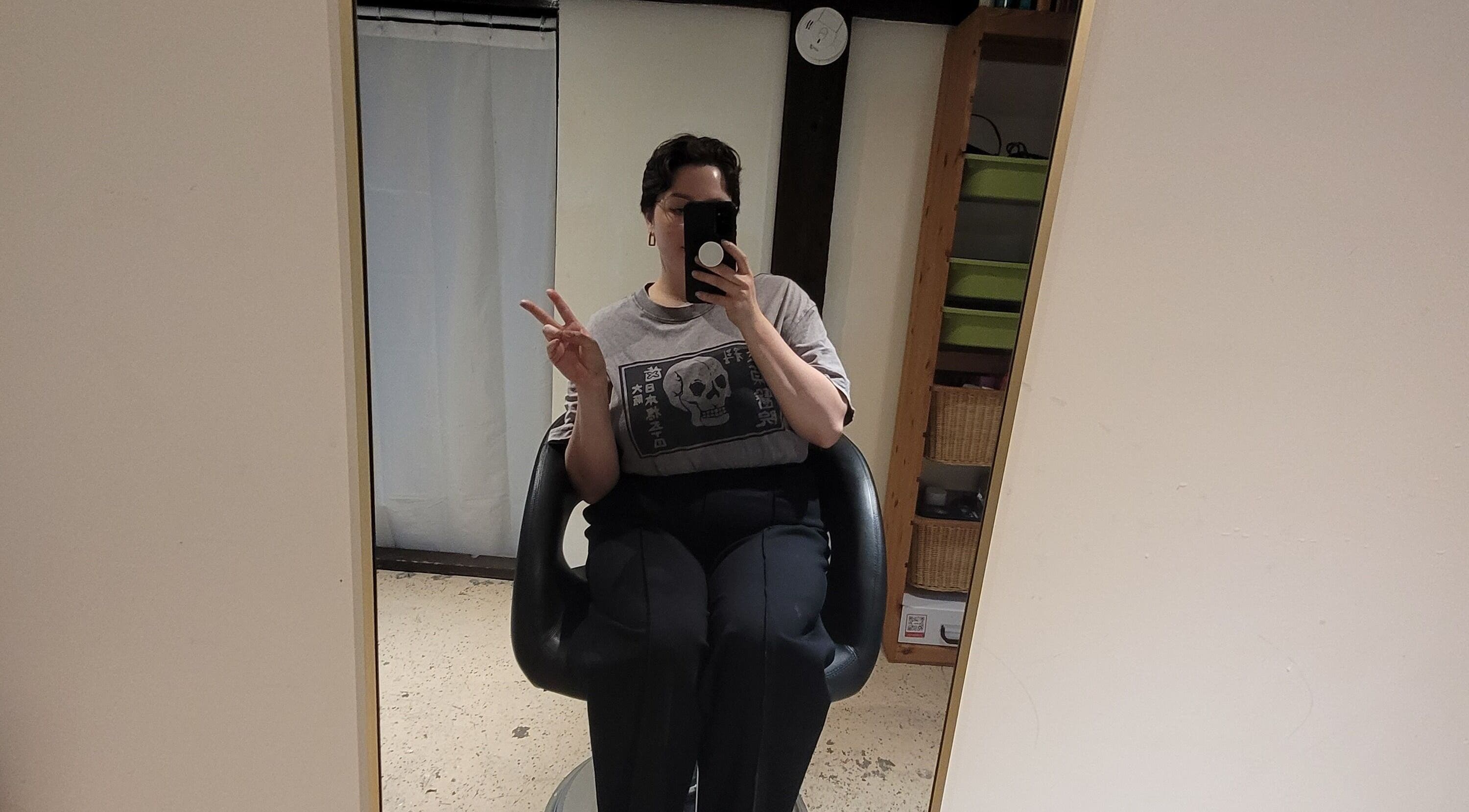 Relaxed individual in salon chair at Styled By Tylore, Vancouver, British Columbia, CA displaying peace sign.