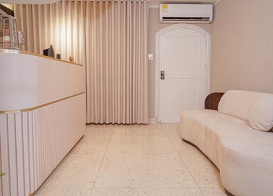 Recepción elegante en Fiore studio, Barranquilla, Atlántico, CO. Espacio acogedor con sofá y mostrador moderno.