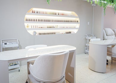 Mesa de manicura elegante en Fiore Studio, Barranquilla, Atlántico, CO, con sillas cómodas y esmaltes alineados.