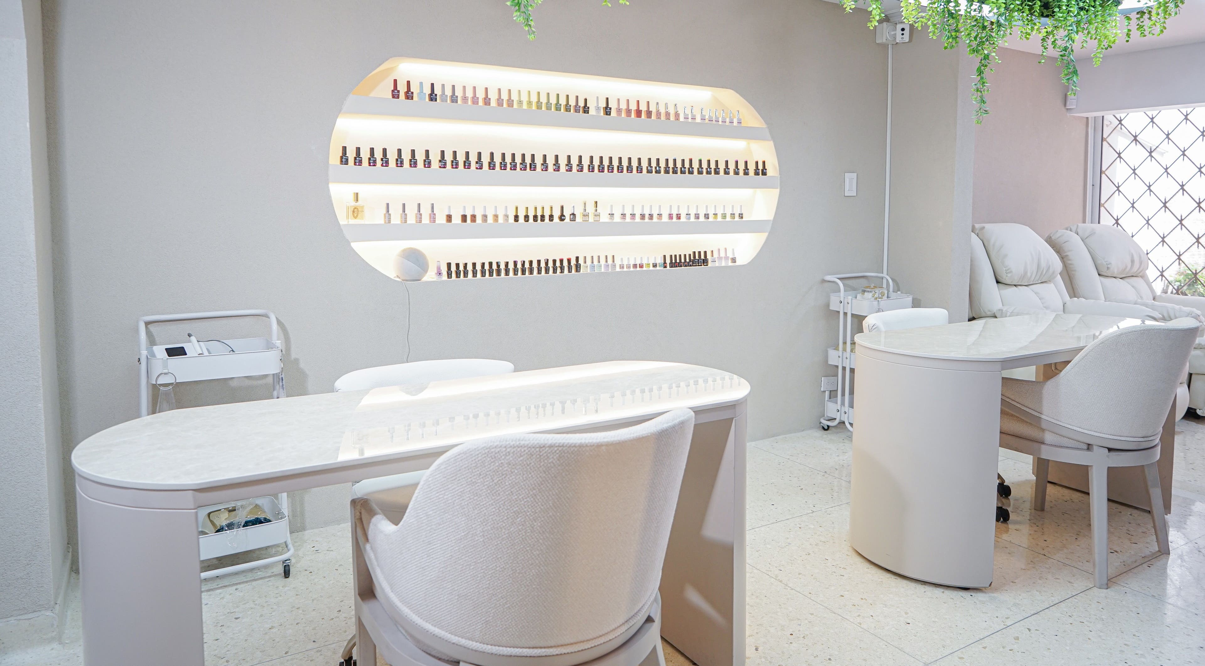 Mesa de manicura elegante en Fiore Studio, Barranquilla, Atlántico, CO, con sillas cómodas y esmaltes alineados.