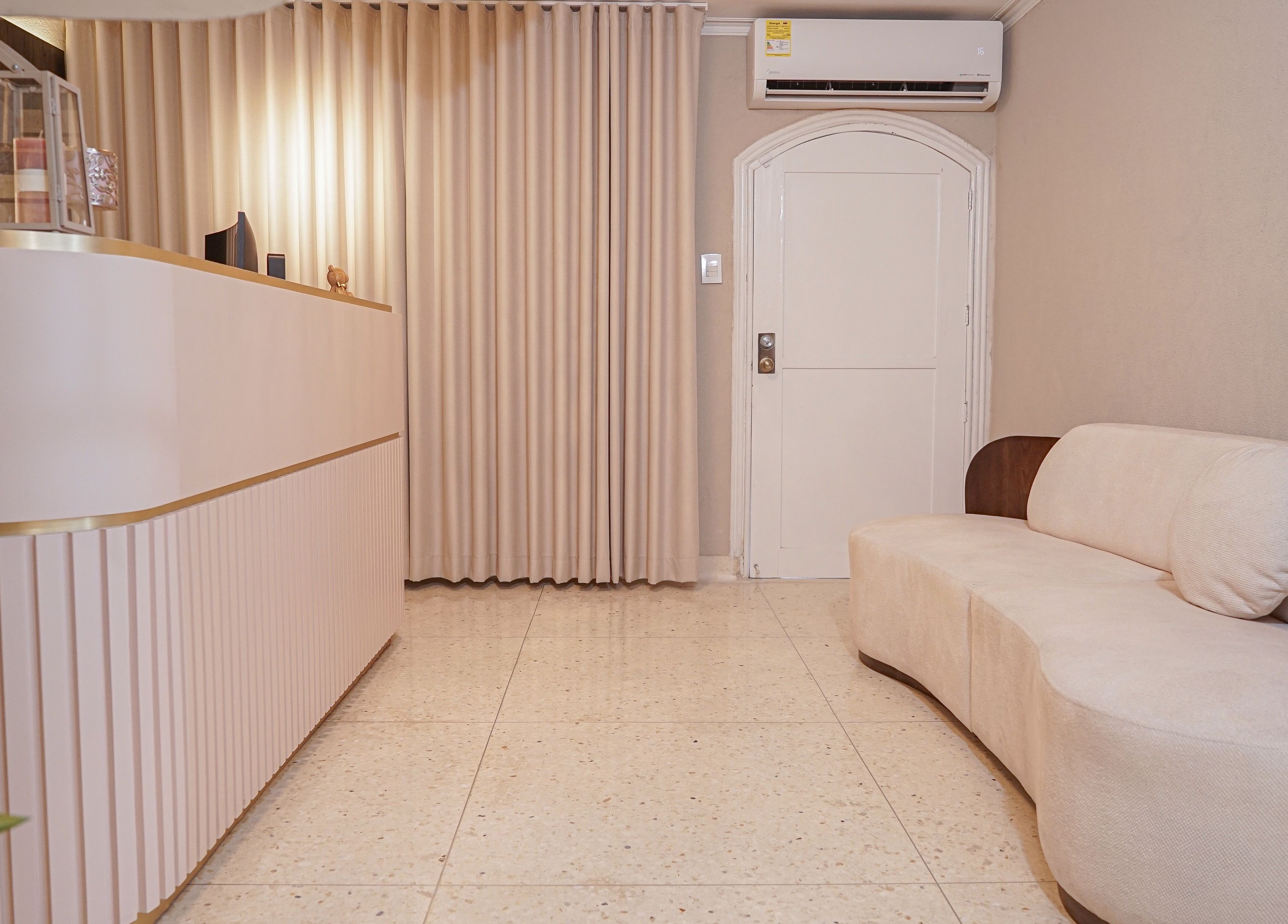 Recepción moderna en Fiore Studio, Barranquilla, Atlántico, CO con sofá beige y cortinas elegantes.