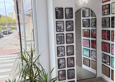 Sala de Yutori Barberia en A Coruña, ES con decoración moderna y cuadros vibrantes.
