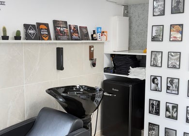 Decoración moderna de Yutori Barberia en A Coruña, ES, con sillas negras y estantería de libros.