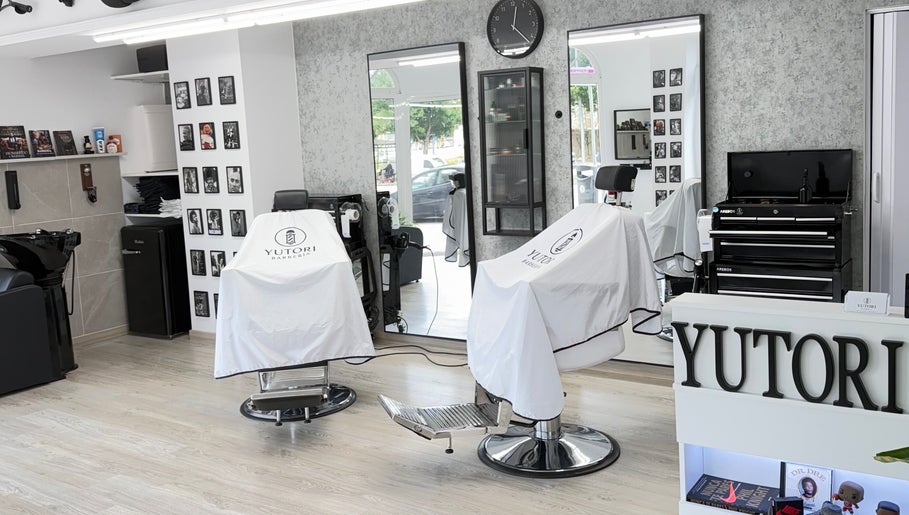 Interior de Yutori Barberia en A Coruña, ES, con sillas elegantes y decoración moderna.