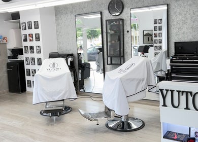 Interior de Yutori Barberia en A Coruña, ES, con sillas elegantes y decoración moderna.