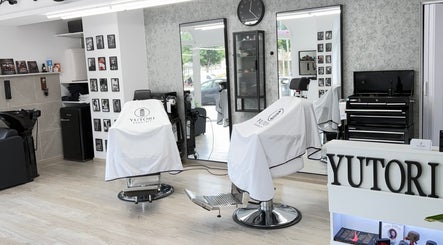 Interior de Yutori Barberia en A Coruña, ES, con sillas elegantes y decoración moderna.