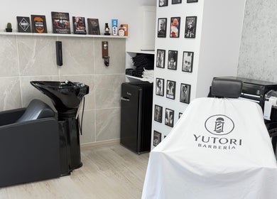 Interior de Yutori Barberia en A Coruña, ES, mostrando sillón y lavacabezas modernos.