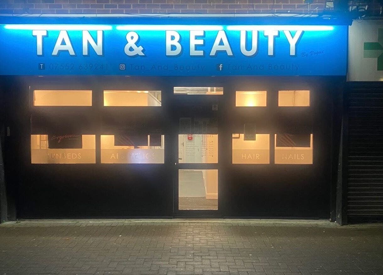 Exterior view of Extensions by Rebecca's illuminated storefront in Wythenshawe, England, GB at night.