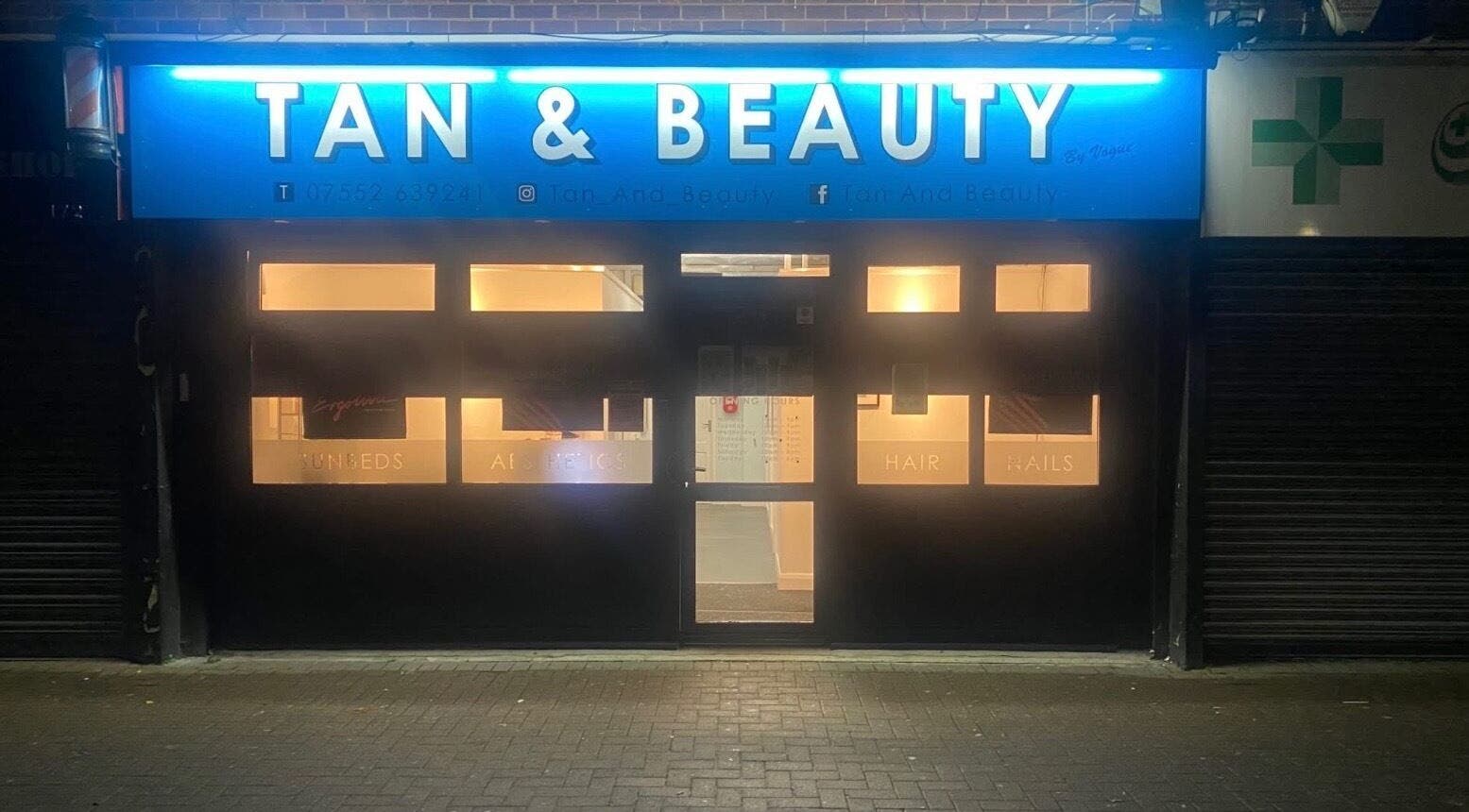 Exterior view of Extensions by Rebecca's illuminated storefront in Wythenshawe, England, GB at night.