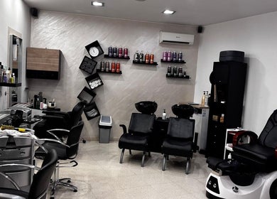 Interior moderno del Salón De Belleza Quezia en Sabadell, Catalunya, ES, con estaciones de peluquería y productos.