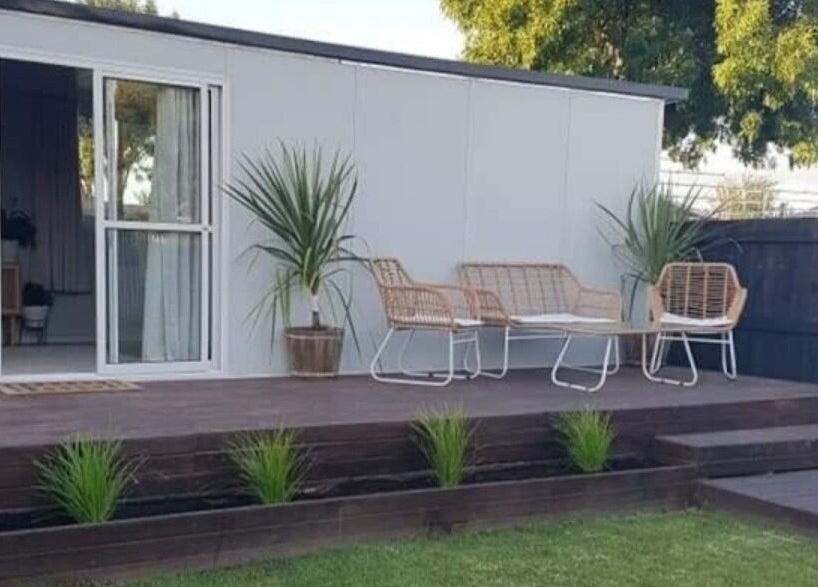 Outdoor seating area at My Little Oasis, Palmerston North, Manawatū-whanganui, NZ, featuring stylish wicker chairs.