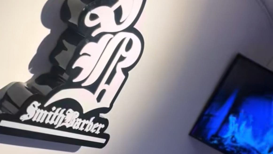 Logotipo de Smith Barber en Dosquebradas, Risaralda, CO al lado de una pantalla moderna.