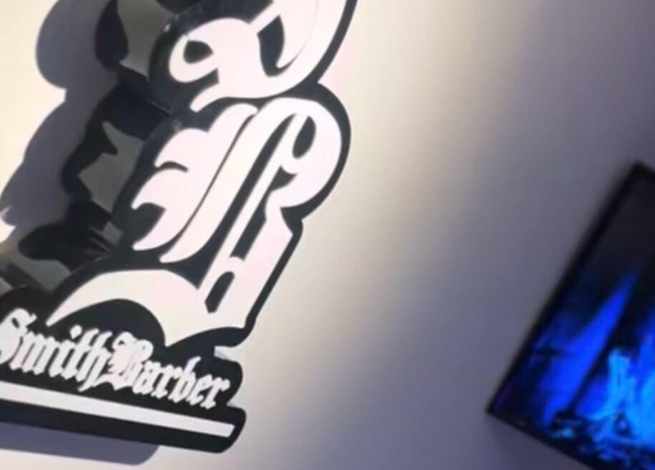 Logotipo de Smith Barber en Dosquebradas, Risaralda, CO al lado de una pantalla moderna.