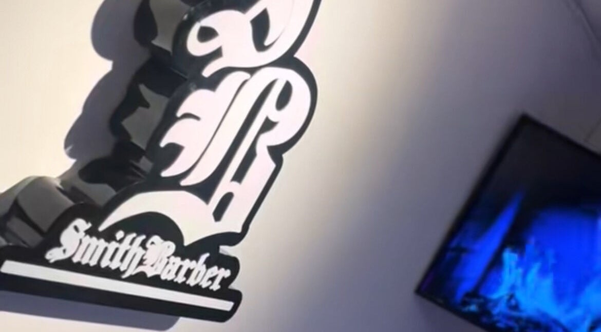 Logotipo de Smith Barber en Dosquebradas, Risaralda, CO al lado de una pantalla moderna.