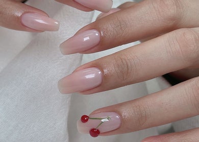 Elegant cherry nail art at Niko Nail Studio, La Verne, California, US. Perfectly manicured hands showcasing unique design.