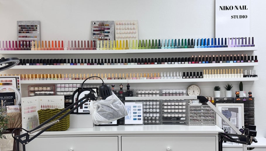 Nail polish collection at Niko Nail Studio, La Verne, California, US. A colorful array of bottles on shelves.
