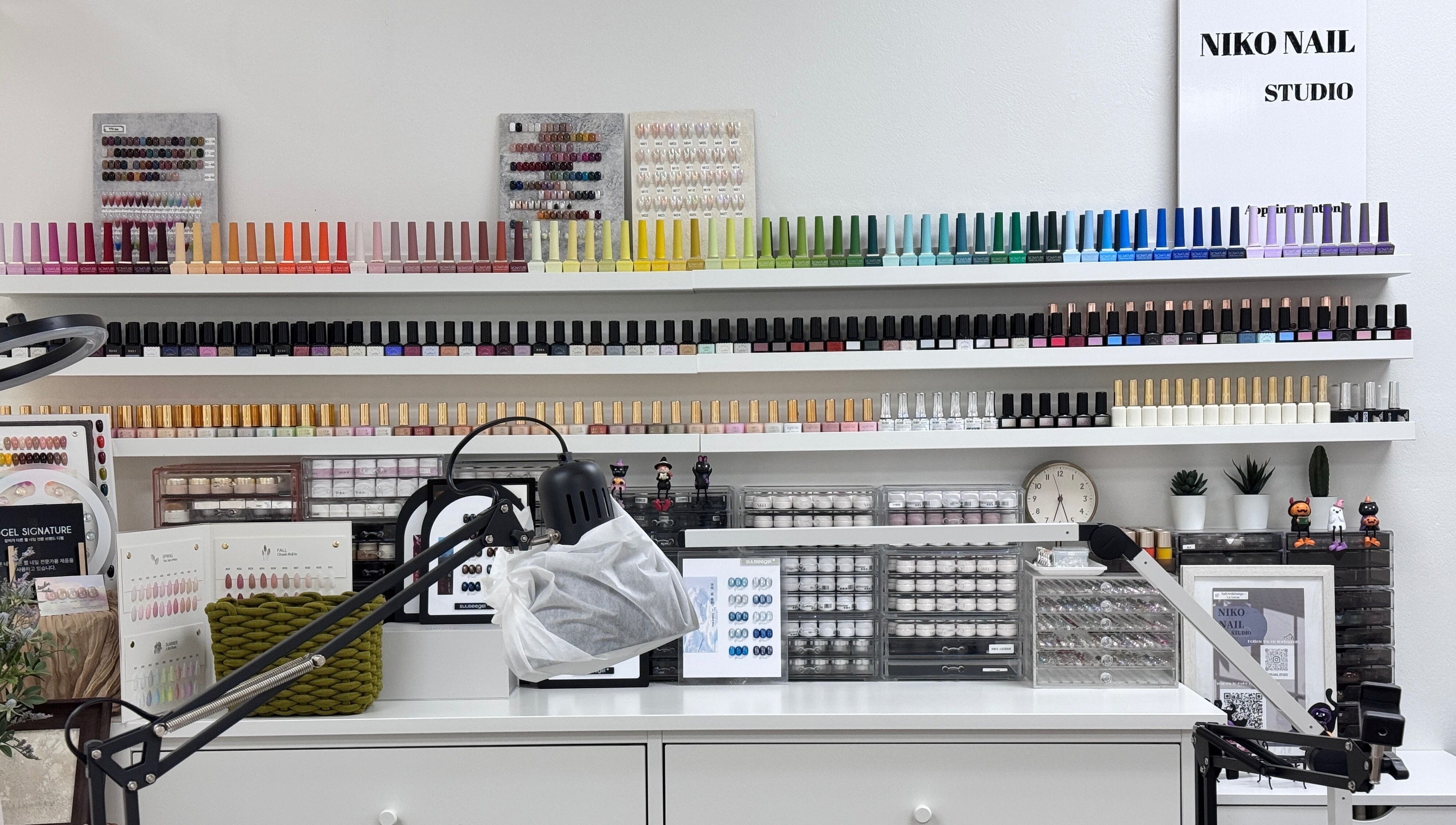 Nail polish collection at Niko Nail Studio, La Verne, California, US. A colorful array of bottles on shelves.