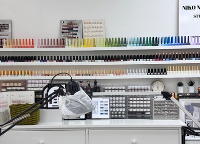 Nail polish collection at Niko Nail Studio, La Verne, California, US. A colorful array of bottles on shelves.
