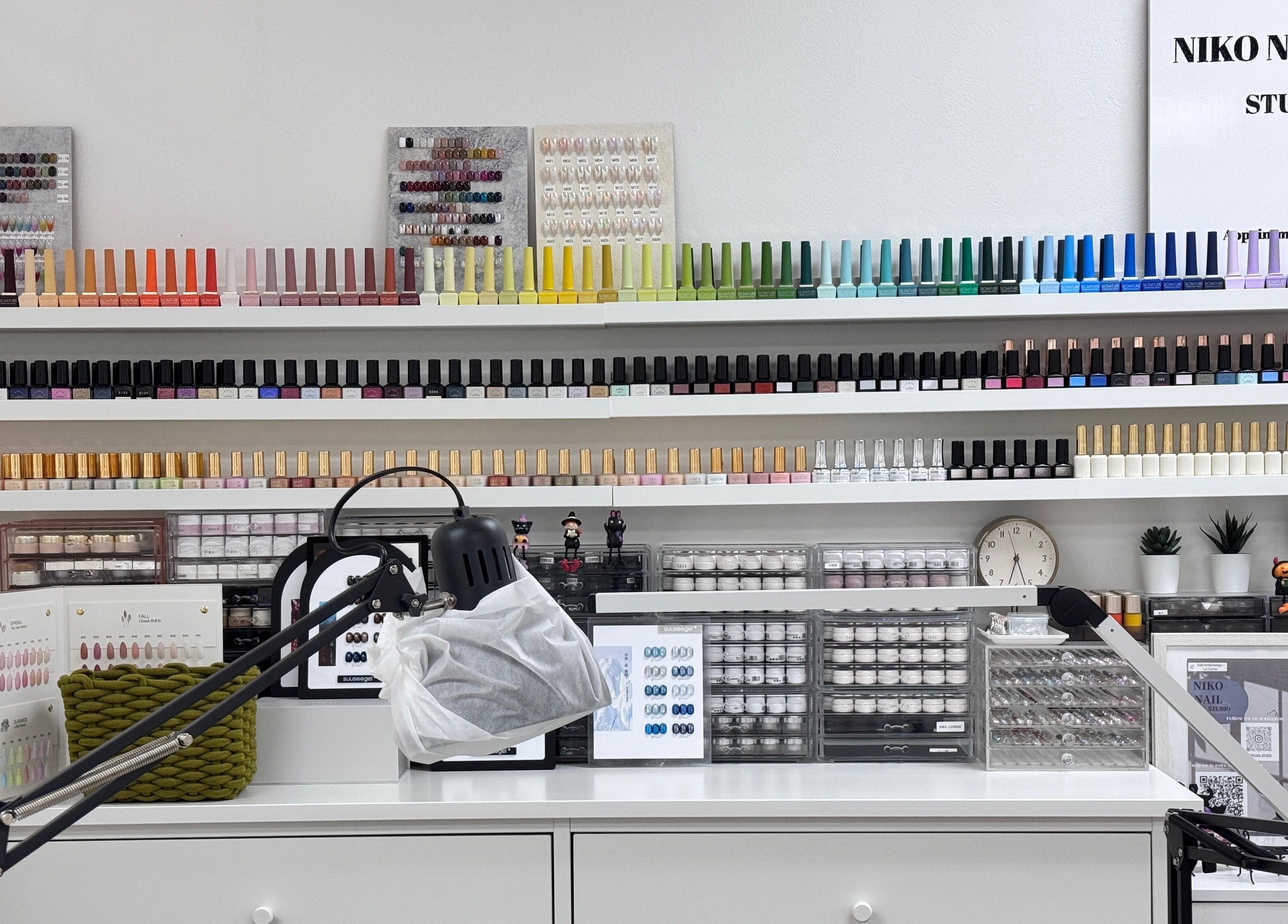 Nail polish collection at Niko Nail Studio, La Verne, California, US. A colorful array of bottles on shelves.