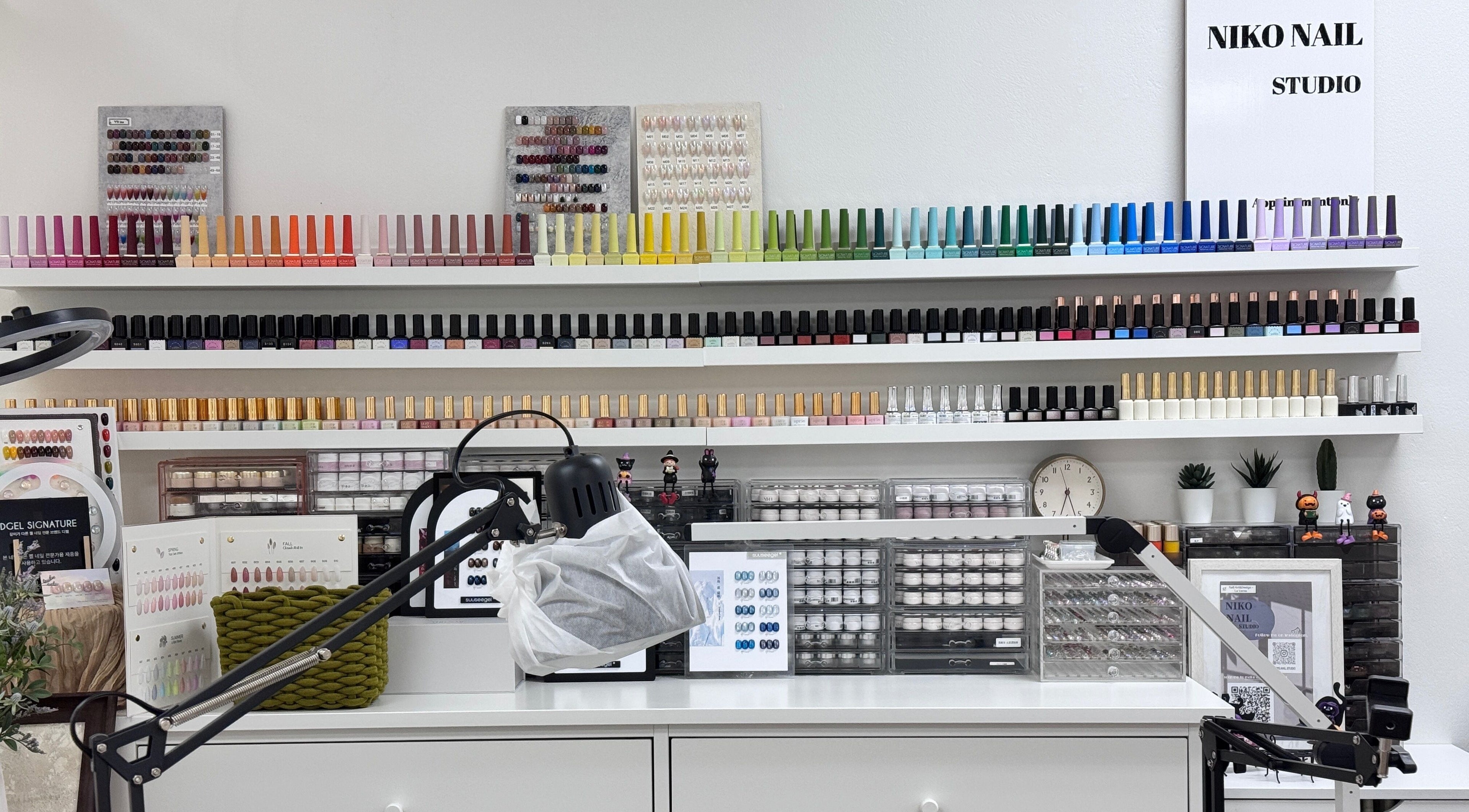 Nail polish collection at Niko Nail Studio, La Verne, California, US. A colorful array of bottles on shelves.