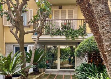 Lush garden entrance of Kobido Mallorca in Palma, Illes Balears, ES with palm trees and greenery.