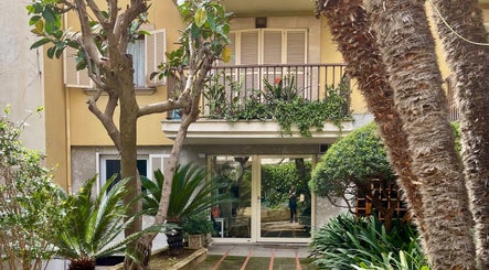 Lush garden entrance of Kobido Mallorca in Palma, Illes Balears, ES with palm trees and greenery.