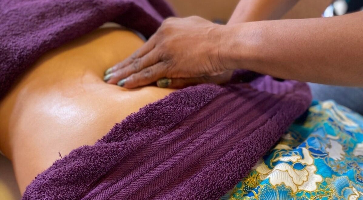 Relaxing massage at Guided Souls in Grifton, North Carolina, US, with purple towel and floral mat.