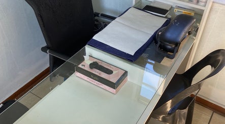 Manicure station at Glow District, Soweto, Gauteng, ZA, featuring tools on a sleek glass table.