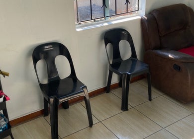 Seating area at Glow District, Soweto, Gauteng, ZA with black chairs and a brown recliner.