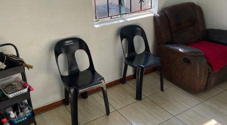Seating area at Glow District, Soweto, Gauteng, ZA with black chairs and a brown recliner.