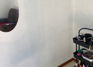 Mirror reflection of a cozy chair and beauty cart at Glow District, Soweto, Gauteng, ZA.