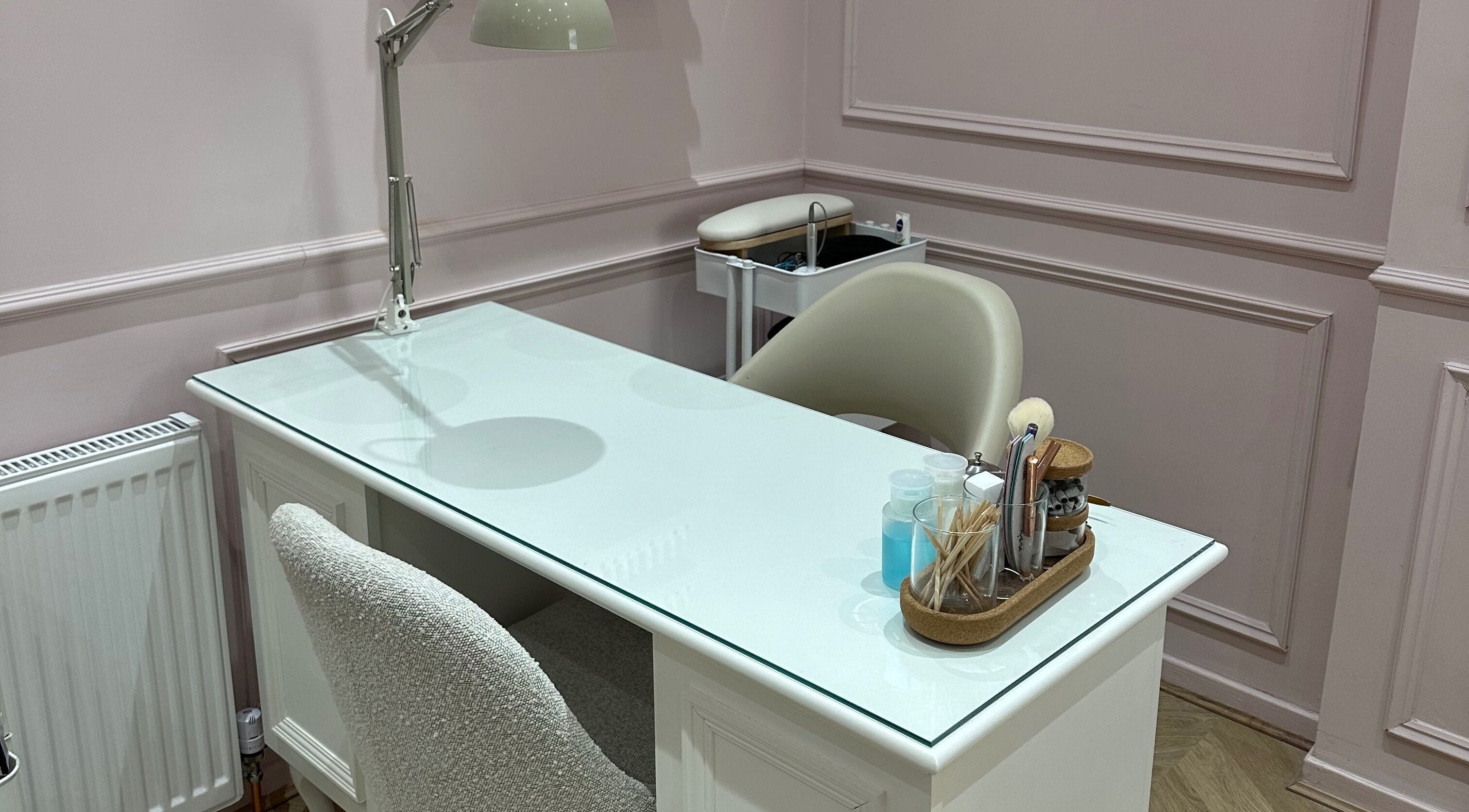 Stylish nail station at Nailsbyklc, Monton, England, GB, featuring a sleek white table and comfortable chair.