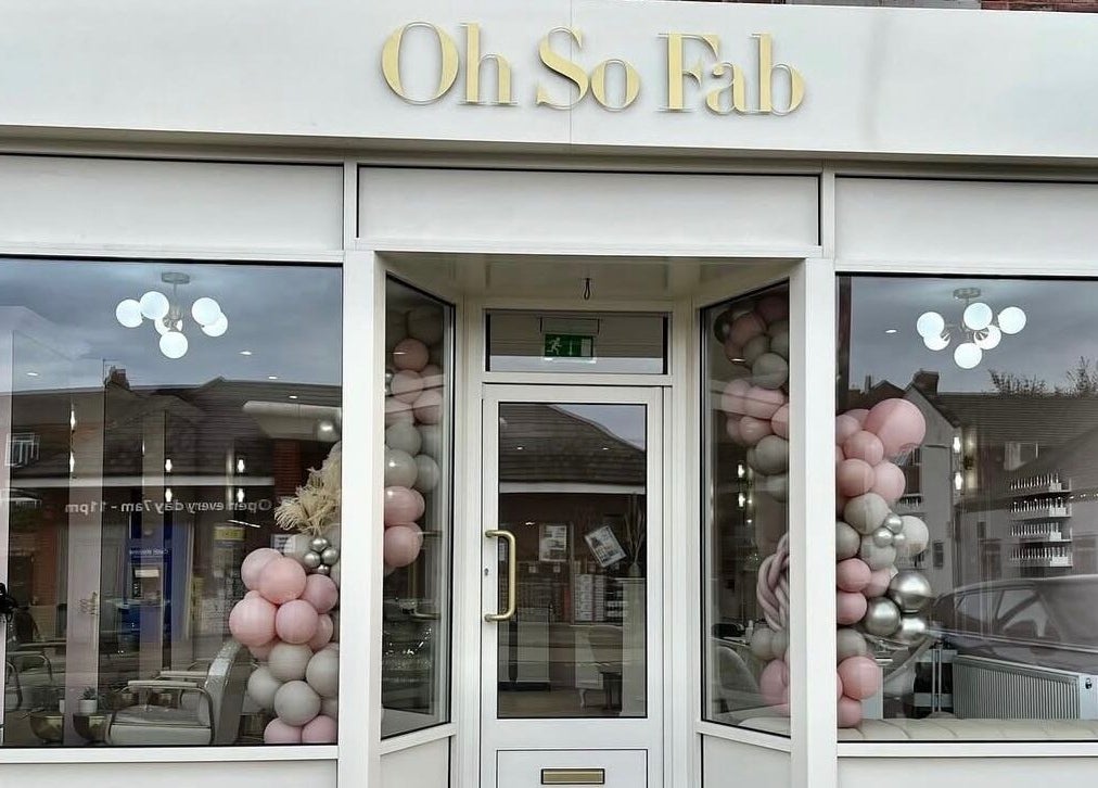 Elegant entrance of Nailsbyklc in Monton, England, GB, with pink and silver balloons adorning display windows.