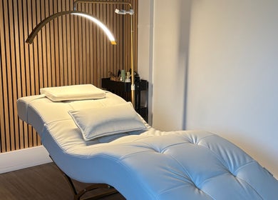 Luxurious treatment room at Defined by Amy Jane in Altrincham, England, GB featuring a plush white lounge chair.