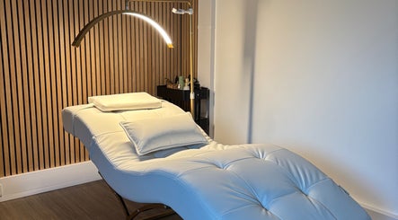 Luxurious treatment room at Defined by Amy Jane in Altrincham, England, GB featuring a plush white lounge chair.