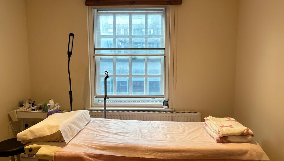 Cozy treatment room at JC Japanese Eyelash in London, England, GB, with a comfortable bed and soft lighting.