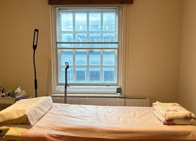 Cozy treatment room at JC Japanese Eyelash in London, England, GB, with a comfortable bed and soft lighting.