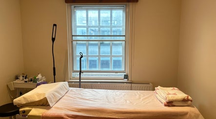 Cozy treatment room at JC Japanese Eyelash in London, England, GB, with a comfortable bed and soft lighting.